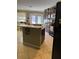A kitchen with tan tile floors, an island, and a large black refrigerator at 8 E Summit St, Apopka, FL 32712