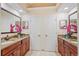 Dual vanity bathroom featuring wood cabinets, granite countertops, and decorative accents creating a functional space at 8453 Firefox Cv, Orlando, FL 32835