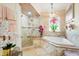 Elegant bathroom with a soaking tub, tiled shower, and a stained glass window offering a luxurious spa experience at 8453 Firefox Cv, Orlando, FL 32835