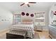 Bright bedroom featuring a luxurious bed, decorative accents, and abundant natural light from large windows at 8453 Firefox Cv, Orlando, FL 32835