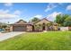 Charming single-story brick home with a well-manicured lawn, two-car garage, and palm tree landscaping at 8453 Firefox Cv, Orlando, FL 32835