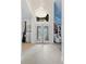 Elegant foyer with tiled floor, double doors, and a dazzling crystal chandelier at 8453 Firefox Cv, Orlando, FL 32835
