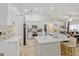 Open-concept kitchen and dining area with white cabinets, gold hardware, and a large center island at 8453 Firefox Cv, Orlando, FL 32835