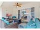 Inviting covered patio with comfortable seating, TV, leaf ceiling fan and sliding glass doors to the interior at 8453 Firefox Cv, Orlando, FL 32835