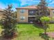 Backyard view of a two-story building with a patio and lush lawn at 8925 Azalea Sands Ln # 602, Davenport, FL 33896