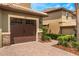 Attached garage with brick-paved driveway and well-maintained landscaping, showcasing the home's exterior at 8925 Azalea Sands Ln # 602, Davenport, FL 33896