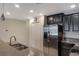 Modern kitchen featuring stainless steel appliances, dark cabinetry, and granite countertops at 8925 Azalea Sands Ln # 602, Davenport, FL 33896