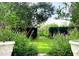 Well-manicured backyard garden with flowers, shrubs, and a lush green lawn at 29540 Deerwood Farms Rd, Sorrento, FL 32776
