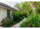 Landscaped side of house with beautiful plants, trees, and a stone path at 29540 Deerwood Farms Rd, Sorrento, FL 32776