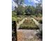Organized garden beds offer diverse plantings and charming pathways at 29540 Deerwood Farms Rd, Sorrento, FL 32776