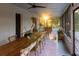Beautiful screened-in porch with a rustic wooden dining table and view of the yard at 29540 Deerwood Farms Rd, Sorrento, FL 32776