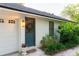 Side entrance featuring a door with a wreath, a garage, and lush landscaping at 29540 Deerwood Farms Rd, Sorrento, FL 32776
