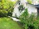 Side yard with white brick, green foliage, and a white gravel path at 29540 Deerwood Farms Rd, Sorrento, FL 32776