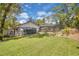 A big backyard showing the pool, the pool screen and a greenhouse on a grassy lot at 105 Valley Ct, Longwood, FL 32779