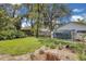Large backyard features a greenhouse, grass and mature trees in a lush setting at 105 Valley Ct, Longwood, FL 32779