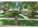 Charming brick home with manicured lawn and walkway features a welcoming entryway and lush landscaping at 105 Valley Ct, Longwood, FL 32779