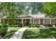 Charming brick home with manicured lawn, walkway, and mature landscaping; features a welcoming entryway at 105 Valley Ct, Longwood, FL 32779