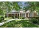 Charming brick home with manicured lawn, walkway, and mature landscaping; features a welcoming entryway at 105 Valley Ct, Longwood, FL 32779