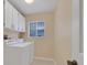Bright laundry room featuring white cabinets, window and modern washer and dryer at 105 Valley Ct, Longwood, FL 32779