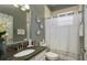 Cozy bathroom with granite countertop, decorative mirror, and white shower curtain at 10879 Norcross Cir, Orlando, FL 32825