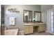 Well-lit bathroom with a double vanity, two mirrors, and decorative accents at 10879 Norcross Cir, Orlando, FL 32825