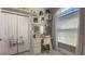 Bright bedroom features charming vanity with lighted mirror, ample storage, and a large sunny window at 10879 Norcross Cir, Orlando, FL 32825