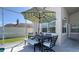 Screened patio with dining set and umbrella, offering outdoor relaxation and entertainment space with a view at 10879 Norcross Cir, Orlando, FL 32825