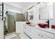 Modern bathroom featuring double sinks with decorative red vessel bowls, glass shower, and vanity at 11718 Fitzgerald Butler Rd, Orlando, FL 32836