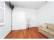 Bright living room with wood floors, white murphy bed, accent furniture and natural light from window with shutters at 11718 Fitzgerald Butler Rd, Orlando, FL 32836