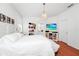 Bright and airy bedroom with hardwood floors, chandelier, television and modern white furniture at 11718 Fitzgerald Butler Rd, Orlando, FL 32836