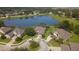 Panoramic aerial view of homes surrounding a pond with a fountain, showcasing a serene neighborhood setting at 128 Hallstrom Ct, Debary, FL 32713