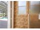 Elegant bathroom featuring neutral color scheme, patterned walls, glass shower door and an open view of the pool area at 128 Hallstrom Ct, Debary, FL 32713