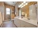 Bathroom with a double sink vanity, large mirror, and a separate glass-enclosed shower, all adorned with a neutral color palette at 128 Hallstrom Ct, Debary, FL 32713