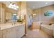 Inviting bathroom featuring a soaking tub, glass shower, and a vanity with double sinks, with bright neutral tones at 128 Hallstrom Ct, Debary, FL 32713