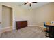 Neutral bedroom with carpet, a window with shutters, and a wood dresser and blue chair at a desk at 128 Hallstrom Ct, Debary, FL 32713