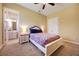 Charming bedroom with vibrant floral bedding, fan, and a view into an attached bathroom at 128 Hallstrom Ct, Debary, FL 32713