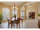 Formal dining room area showcasing a chandelier, large window, and an open layout to the home's entryway at 128 Hallstrom Ct, Debary, FL 32713