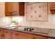 A detailed close-up of a modern kitchen features dark wood cabinetry and stylish backsplash at 128 Hallstrom Ct, Debary, FL 32713