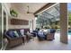 Covered outdoor living space with comfortable seating, bar area, and views of the pool and backyard at 128 Hallstrom Ct, Debary, FL 32713
