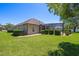 Well-maintained backyard with a screened-in lanai, mature trees, and lush landscaping at 128 Hallstrom Ct, Debary, FL 32713