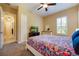 This bedroom has a ceiling fan, closet, TV and a colorful bedspread and entry to hallway at 128 Hallstrom Ct, Debary, FL 32713