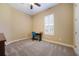 Bedroom with a small desk set up in front of a window with a plantation shutter and carpet flooring at 128 Hallstrom Ct, Debary, FL 32713