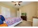 This bedroom has a ceiling fan, closet, TV and a colorful bedspread at 128 Hallstrom Ct, Debary, FL 32713