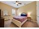 This bedroom has a ceiling fan, closet, dresser and a colorful bedspread at 128 Hallstrom Ct, Debary, FL 32713