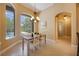 Bright dining area with modern chandelier and views of the pool and outdoor space through large windows at 128 Hallstrom Ct, Debary, FL 32713