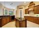 Spacious kitchen with island, custom cabinets, granite countertops, and views of pool area through large windows at 128 Hallstrom Ct, Debary, FL 32713