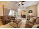 Inviting living room with plush seating, ceiling fan, and stylish decor, seamlessly connected to kitchen area at 128 Hallstrom Ct, Debary, FL 32713