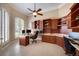 This home office features custom wooden cabinets, a tiled floor, and a large window at 128 Hallstrom Ct, Debary, FL 32713