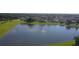 Aerial view of the tranquil pond with a fountain, surrounded by lush greenery and homes at 128 Hallstrom Ct, Debary, FL 32713