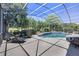 Spacious screened-in lanai and pool area surrounded by lush landscaping and comfortable seating at 128 Hallstrom Ct, Debary, FL 32713